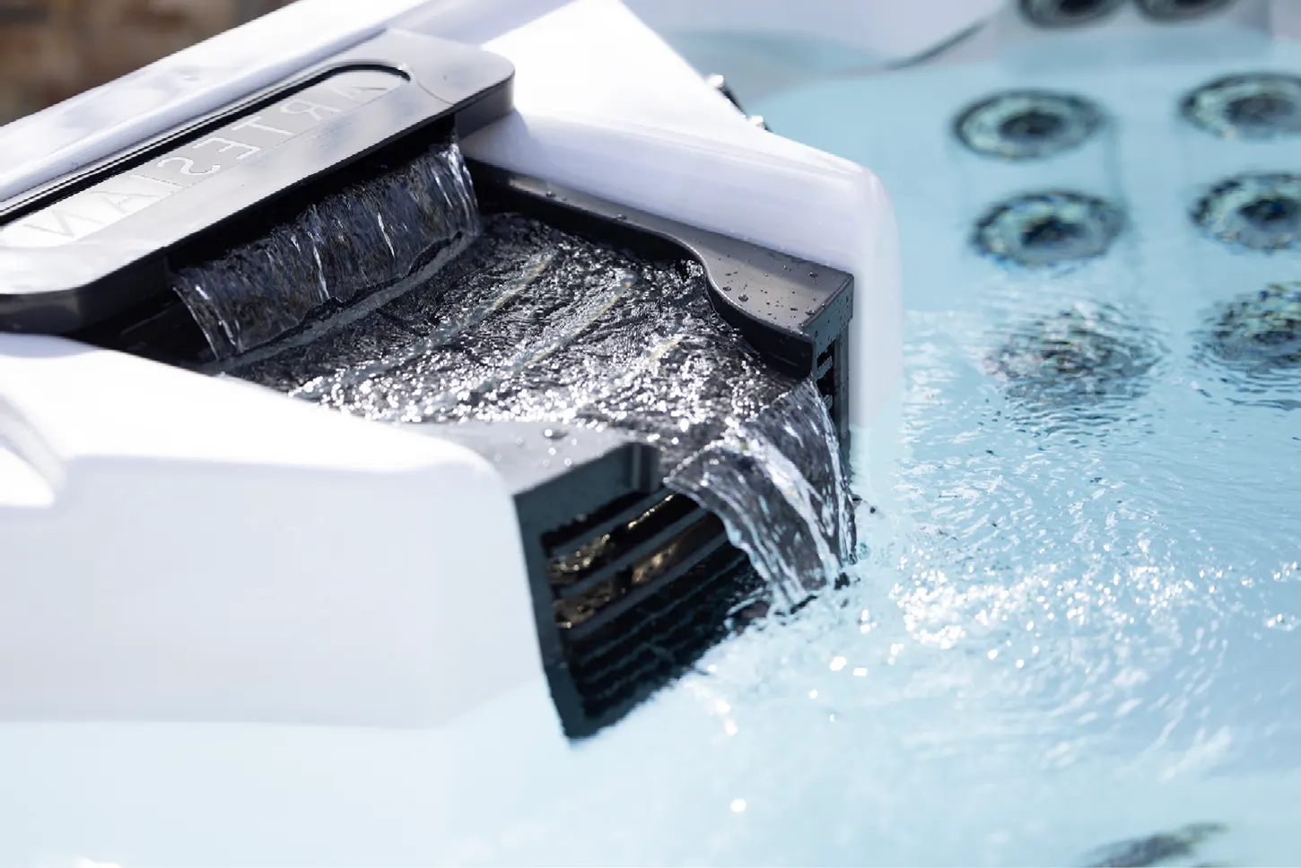 Close view of a spa waterfall feature with steam rising