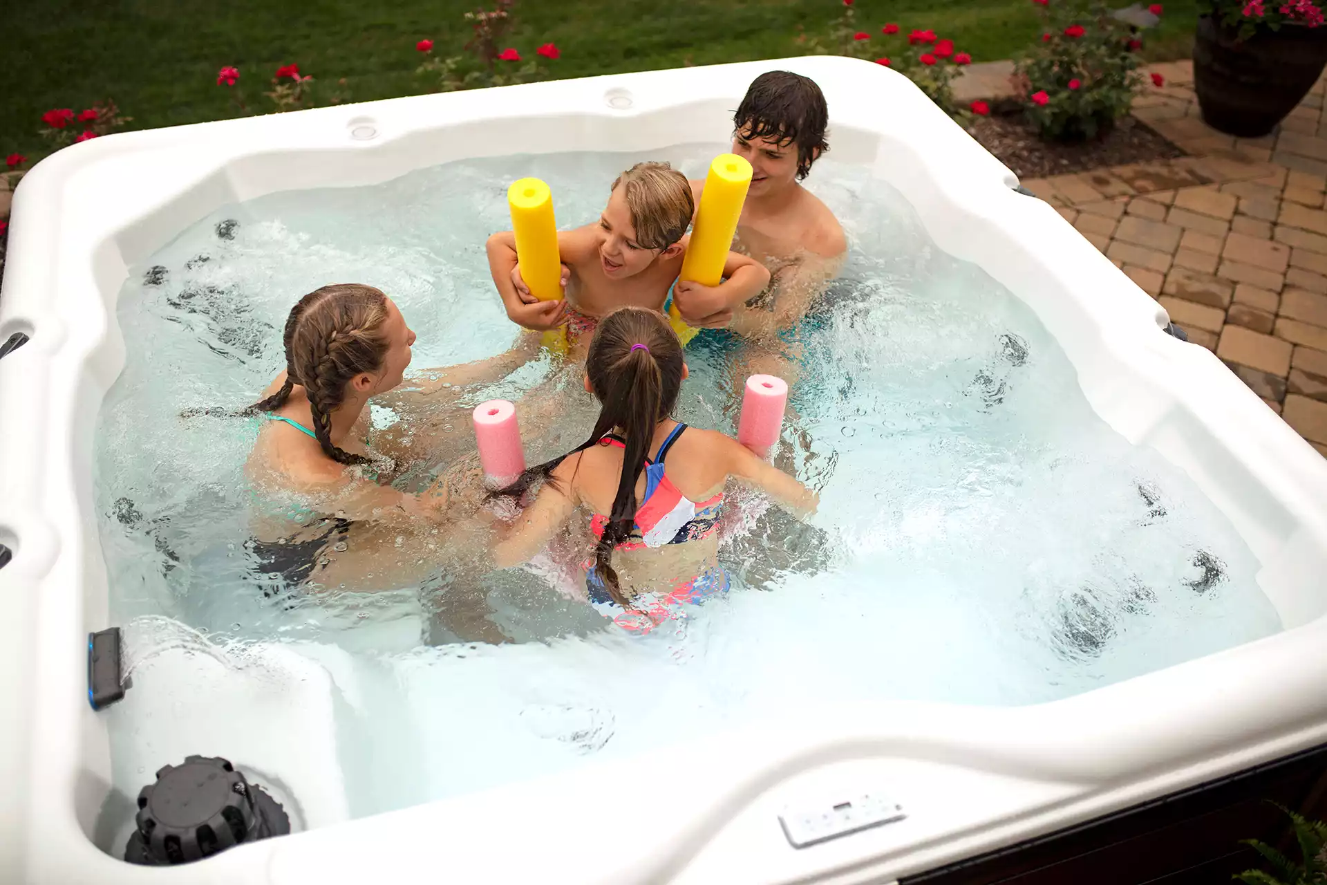 Family relaxing together in a warm hot tub on a cool evening